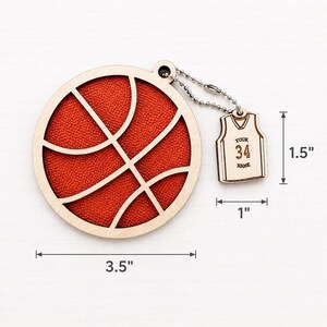 A wooden basketball ornament and a mini jersey tag are shown on a light surface with dimension measurements of 3.5 inches wide, 1 inch, and 1.5 inches.
