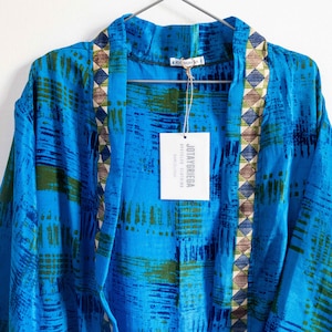 Może przedstawiać: Niebieski i zielony kimono z brązowymi i beżowymi ozdobnymi paskami. Kimono ma metkę z napisem "JOYAYRIEGA" i "TEXTILE DESIGN".