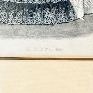 K&ouml;nnte beinhalten: Ein Schwarzwei&szlig;druck von zwei Frauen in aufwendigen Kleidern. Der Druck ist gerahmt und tr&auml;gt unten den Text "LES MODES PARISIENNES".