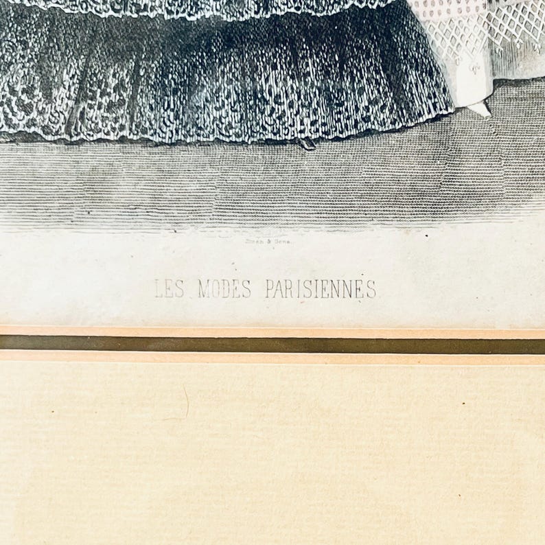 K&ouml;nnte beinhalten: Ein Schwarzwei&szlig;druck von zwei Frauen in aufwendigen Kleidern. Der Druck ist gerahmt und tr&auml;gt unten den Text "LES MODES PARISIENNES".