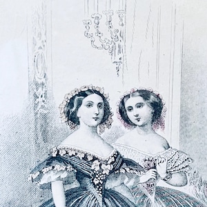 K&ouml;nnte beinhalten: Zwei Frauen in Kleidern aus dem 19. Jahrhundert mit Blumenkr&auml;nzen. Die Frau links tr&auml;gt ein dunkelblaues Kleid mit einem wei&szlig;en Blumenmuster. Die Frau rechts tr&auml;gt ein wei&szlig;es Kleid mit einem Blumenmuster und eine rosa Rose in der Hand.