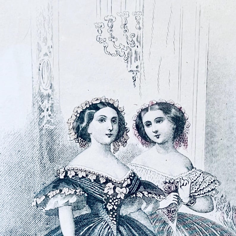 K&ouml;nnte beinhalten: Zwei Frauen in Kleidern aus dem 19. Jahrhundert mit Blumenkr&auml;nzen. Die Frau links tr&auml;gt ein dunkelblaues Kleid mit einem wei&szlig;en Blumenmuster. Die Frau rechts tr&auml;gt ein wei&szlig;es Kleid mit einem Blumenmuster und eine rosa Rose in der Hand.