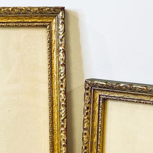 K&ouml;nnte beinhalten: Zwei verzierte goldene Bilderrahmen mit einem dekorativen, erhabenen, gemusterten Rand. Die Rahmen sind leer und bereit, Kunstwerke oder Fotos zu pr&auml;sentieren.