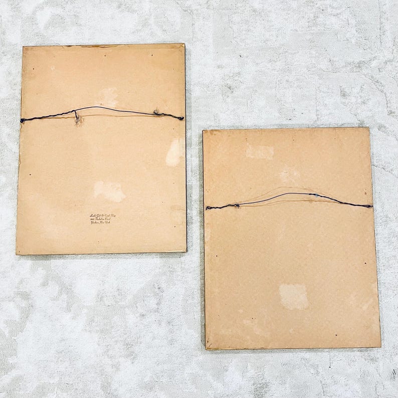 K&ouml;nnte beinhalten: Zwei braune Bilderrahmen mit einem einfachen schwarzen Draht-Aufh&auml;ngesystem auf der R&uuml;ckseite. Die Rahmen sind beide rechteckig und haben eine hellbraune Pappe als R&uuml;ckwand.