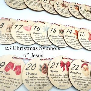 Peut inclure: Un ensemble de 25 ornements circulaires en bois présentant des symboles de Noël et du texte, reliés par une ficelle rouge et blanche. Chaque pièce affiche un numéro, une illustration thématique et un court passage sur le symbole de Jésus.