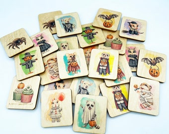 May include: A collection of square wooden tiles featuring colourful Halloween-themed illustrations. The designs include animals in costumes, spiders, pumpkins, and cupcakes, all printed on light-coloured wood with visible grain patterns.