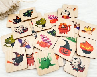 May include: A collection of square wooden tiles featuring Halloween-themed illustrations. The tiles depict various characters like cats, bats, and pumpkins in vibrant colors. A drawstring bag is visible in the background.