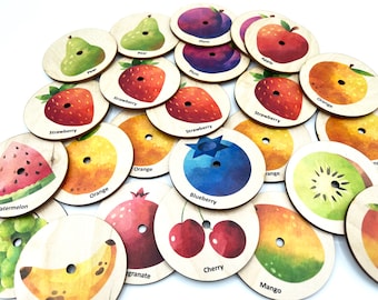May include: Wooden fruit-themed educational game pieces. Each piece features a different fruit illustration, including strawberry, orange, and blueberry, with the fruit's name printed below. The pieces are round with a small hole in the center.