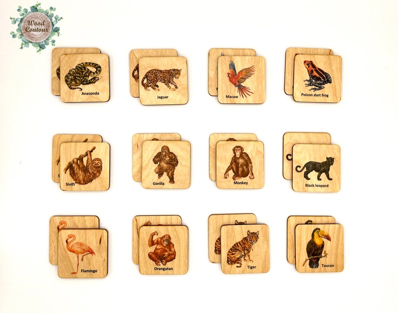 Op de afbeelding: Houten tegels met illustraties van dieren, waaronder een anaconda, jaguar, ara, pijlgifkikker, luiaard, gorilla, aap, zwarte panter, flamingo, orang-oetan, tijger en toekan. De tegels zijn vierkant met afgeronde hoeken.