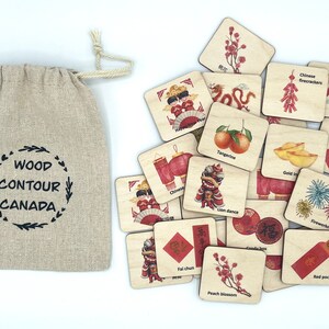 May include: A beige linen drawstring bag with the text WOOD CONTOUR CANADA printed in black, accompanied by a collection of square wooden tiles featuring colorful illustrations of Chinese New Year symbols, including a lion dance, fireworks, and red packets.