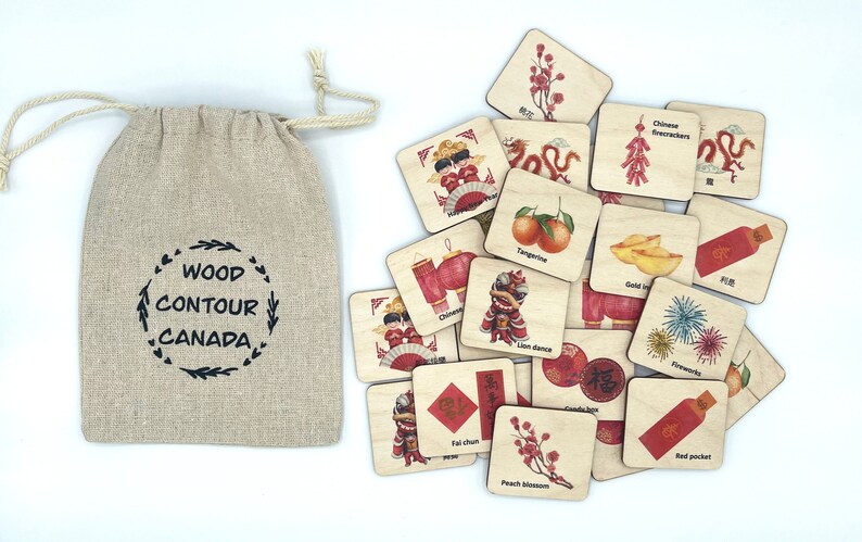 May include: A beige linen drawstring bag with the text WOOD CONTOUR CANADA printed in black, accompanied by a collection of square wooden tiles featuring colorful illustrations of Chinese New Year symbols, including a lion dance, fireworks, and red packets.