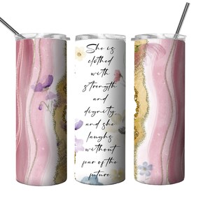 May include: A pink and gold tumbler with a floral design and the quote "She is clothed with strength and dignity, and she laughs without fear of the future."