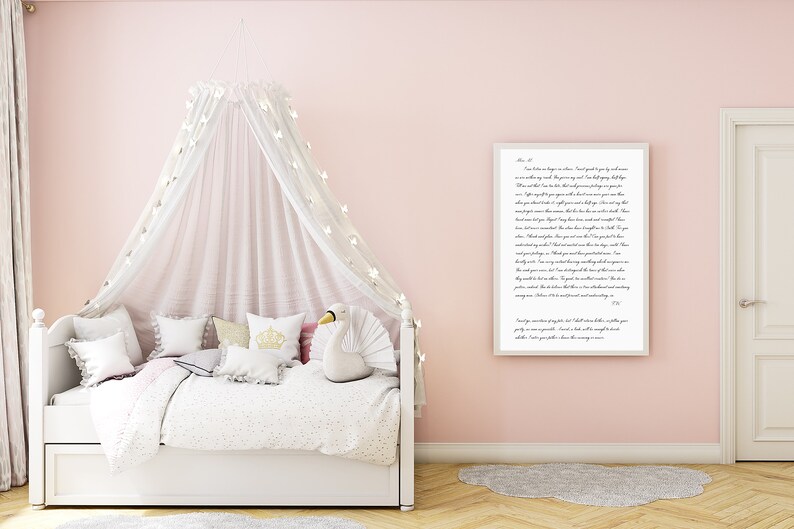 Puede incluir: Una cama con dosel blanco con un juguete de peluche de cisne blanco y una impresi&oacute;n enmarcada con una cita sobre el amor y la amabilidad. La habitaci&oacute;n est&aacute; pintada de un color rosa suave.
