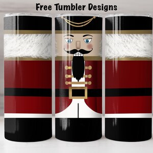 May include: Three stainless steel tumblers featuring a Christmas nutcracker design. The tumblers are red, white, black, and gold. The nutcracker has a blue eye, black beard, and gold buttons.
