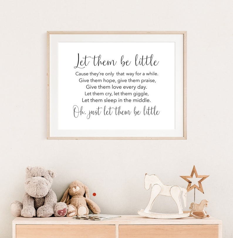 May include: A framed print with a white background and black text that reads "Let them be little. Cause they're only that way for a while. Give them hope, give them praise, Give them love every day. Let them cry, let them giggle, Let them sleep in the middle. Oh, just let them be little."
