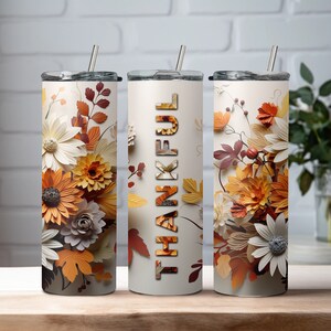 May include: Three stainless steel tumblers with lids and straws. The tumblers feature a floral design with fall colors and the word "THANKFUL" on one of the tumblers.
