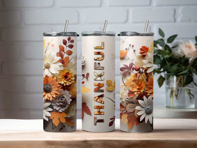 May include: Three stainless steel tumblers with lids and straws. The tumblers feature a floral design with fall colors and the word "THANKFUL" on one of the tumblers.