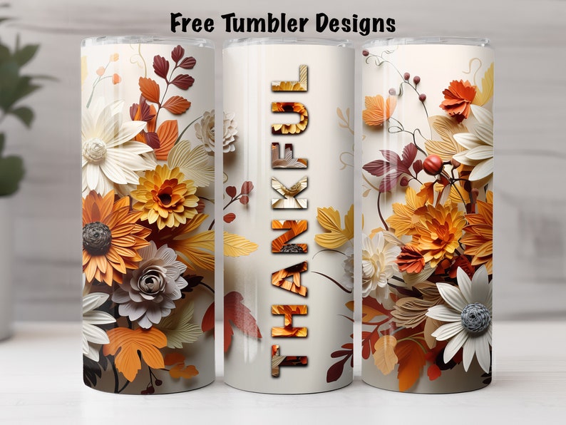 May include: Three stainless steel tumblers with fall-themed designs. The center tumbler features the word "THANKFUL" in large, stylized letters made of fall-colored leaves. The tumblers on either side feature a floral design with white, orange, and brown paper flowers.