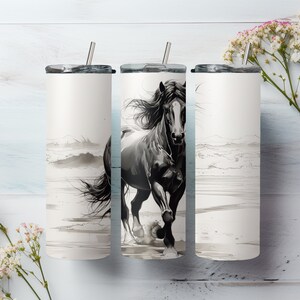 Pode incluir: Tr&ecirc;s copos de a&ccedil;o inoxid&aacute;vel com uma ilustra&ccedil;&atilde;o em preto e branco de um cavalo correndo na praia. Os copos t&ecirc;m tampas e canudos.