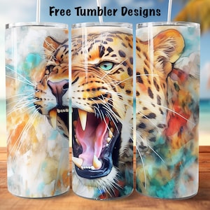 Puede incluir: Tres vasos de acero inoxidable con un diseño de acuarela de un leopardo rugiente. El pelaje del leopardo es marrón y negro sobre un fondo blanco. El diseño está rodeado de un fondo de acuarela colorido.