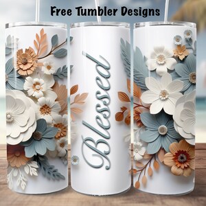 May include: White tumbler with a floral design featuring blue, white, and orange paper flowers. The word "Blessed" is written in blue cursive on the tumbler.