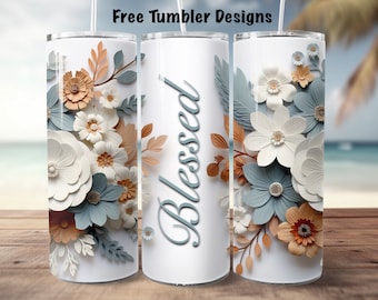 Op de afbeelding: Een witte tumbler met een bloemenontwerp met blauwe, witte en oranje papieren bloemen. Het woord "Blessed" staat in blauwe cursieve letters op de tumbler.