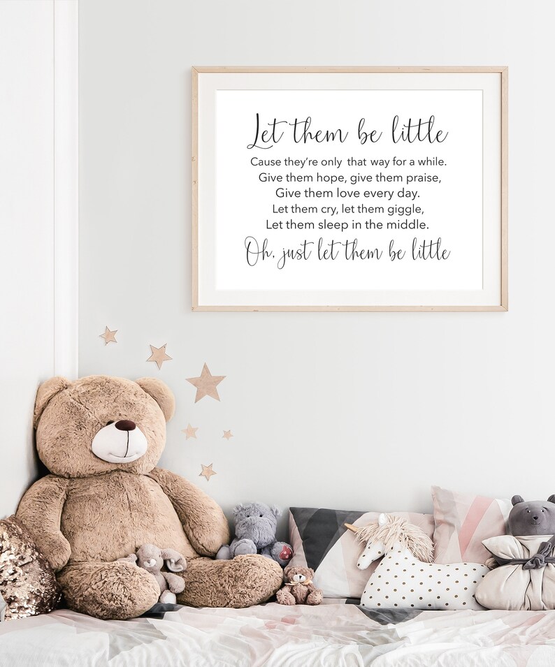 May include: A framed print with a white background and black text that reads "Let them be little. Cause they're only that way for a while. Give them hope, give them praise, Give them love every day. Let them cry, let them giggle, Let them sleep in the middle. Oh, just let them be little."