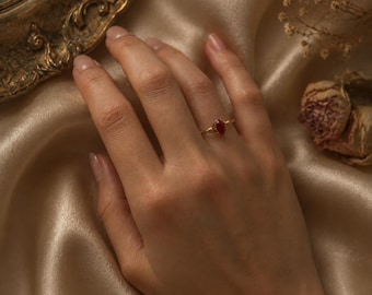 Anillo delicado con piedras preciosas: cuarzo transparente o coral rojo engarzado en alambre de oro.