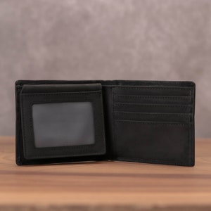 Puede incluir: Una cartera de cuero negro con m&uacute;ltiples ranuras para tarjetas y una ventana de identificaci&oacute;n transparente.