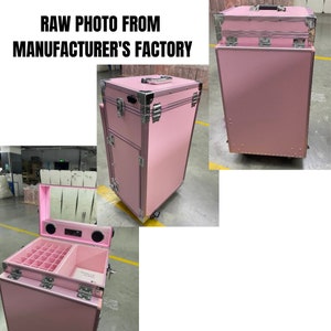 May include: A pink rolling makeup case with silver hardware and a handle. The case has multiple compartments and drawers, and the text "RAW PHOTO FROM MANUFACTURER'S FACTORY" is visible at the top.