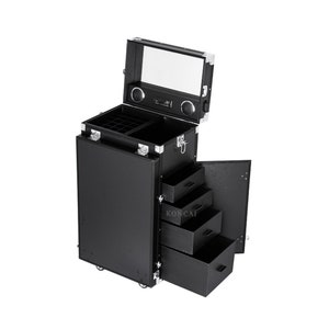 May include: A black rolling makeup case with multiple compartments, drawers, and a mirror. The case has silver-colored corner protectors and a handle. The open drawers reveal storage space. The case is designed for professional makeup artists.