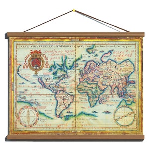 Op de afbeelding: Een vintage wereldkaart gedrukt op perkamentpapier met een houten frame. De kaart is lichtgeel van kleur met blauwe, rode en groene accenten. De kaart toont de continenten Noord-Amerika, Zuid-Amerika, Europa, Azië en Afrika. De kaart is getiteld "CARTE UNIVERSELLE HYDROGRAPHEQVE; Faille par lean Gucrard, l'an 1614."