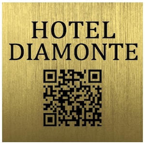 Könnte beinhalten: Ein goldfarbenes Schild mit dem Text "HOTEL DIAMONTE" in fetten schwarzen Buchstaben. Unter dem Text befindet sich ein schwarz-weißer QR-Code. Das Schild hat eine gebürstete Metallstruktur.
