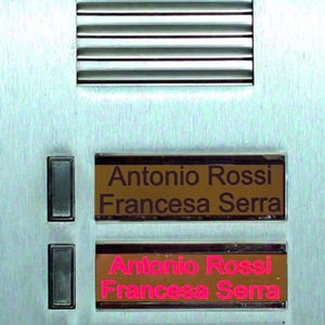 Può includere: Un interfono per porta argentato con due pulsanti e due targhette. Le targhette sono marroni con lettere dorate. La targhetta superiore recita "Antonio Rossi Francesca Serra". La targhetta inferiore recita "Antonio Rossi Francesca Serra".
