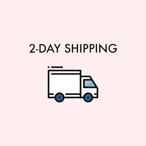 May include: An illustration of a white delivery truck with blue wheels and a blue windshield. The text "2-DAY SHIPPING" is above the truck, all on a light pink background.