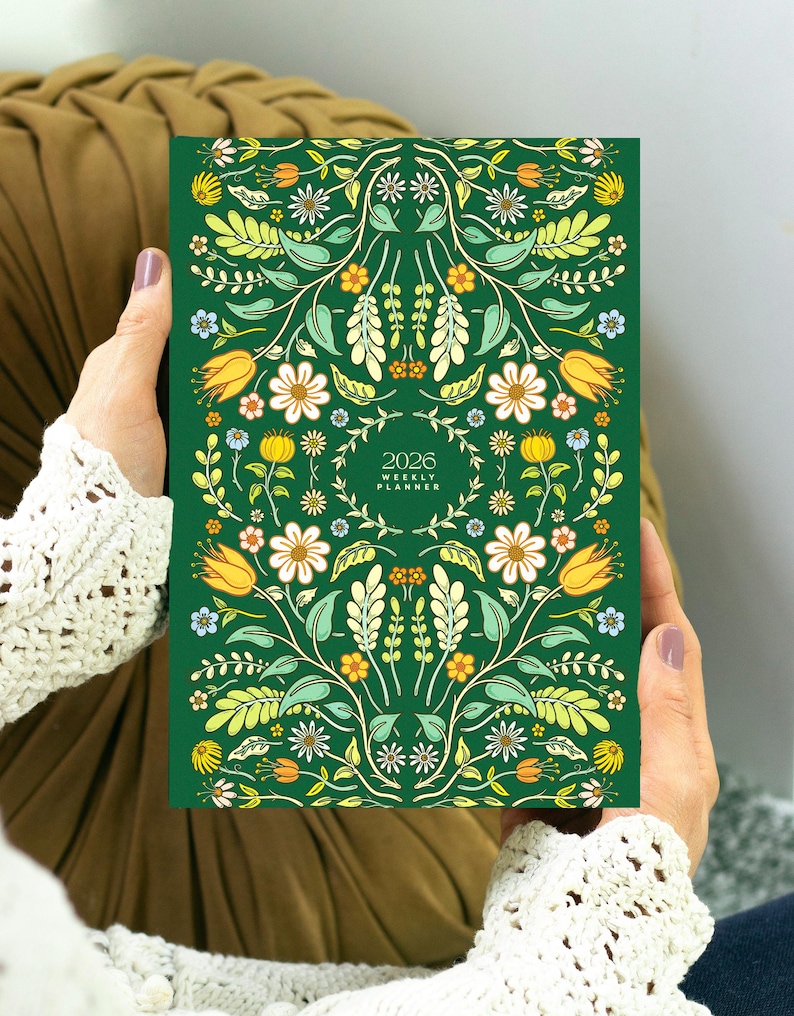Cute 2026 weekly planner featuring folk cover floral illustration. The planner is bound like a book and it's compact and light.
