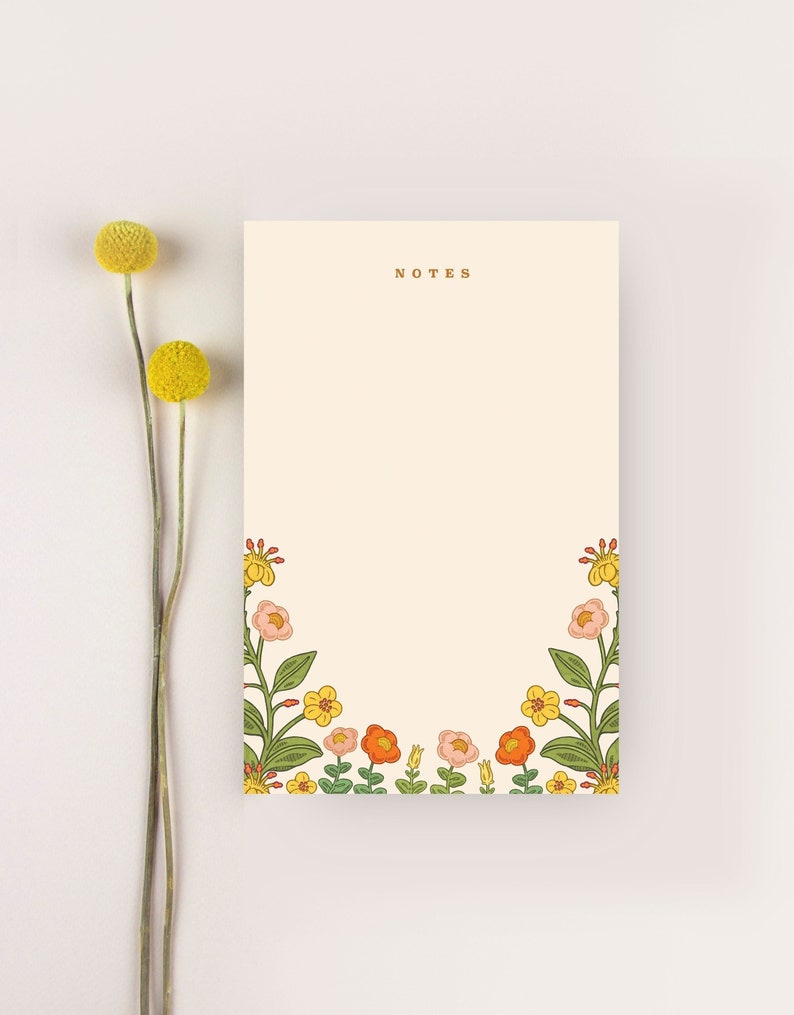 May include: A notepad with a floral border and the word "NOTES" printed at the top. The border features orange, yellow, and pink flowers with green leaves.