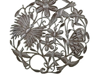 May include: A circular, silver-colored metal wall art piece featuring a detailed design of birds, flowers, butterflies, and leaves. The intricate cut-out design creates a decorative and nature-inspired aesthetic. The piece is suitable for indoor or outdoor display.