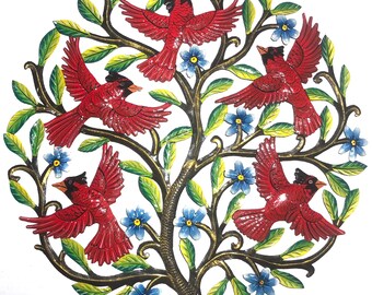 May include: A round metal wall art piece featuring a tree design with five red cardinal birds in flight. The tree has green leaves and blue flowers. The metal is painted with gold, green, red, and blue colors.