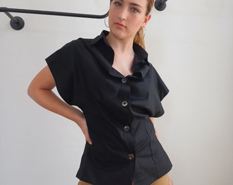 Zwart avant-garde dameshemd met verlaagde schouderopening asymmetrische split kraag V-hals blouse semi-getailleerd chic kantoorshirt minimalistische katoenen top