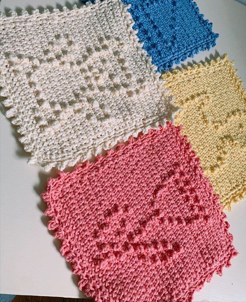 Puede incluir: Cuatro pa&ntilde;os de cocina de ganchillo en diferentes colores: blanco, azul claro, amarillo y rosa. Cada pa&ntilde;o de cocina tiene un patr&oacute;n texturizado en relieve.