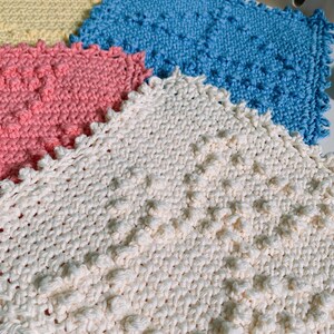 Puede incluir: Cuatro pa&ntilde;os de cocina de ganchillo en diferentes colores: amarillo, azul, rosa y blanco. Los pa&ntilde;os de cocina tienen una superficie texturizada y abultada.