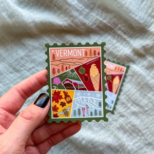 May include: A green sticker in the shape of a postage stamp featuring the word "VERMONT" at the top. The sticker has illustrations of a landscape, an apple, an ice cream cone, and other Vermont-related imagery.