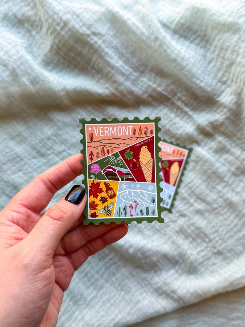 May include: A green sticker in the shape of a postage stamp featuring the word "VERMONT" at the top. The sticker has illustrations of a landscape, an apple, an ice cream cone, and other Vermont-related imagery.