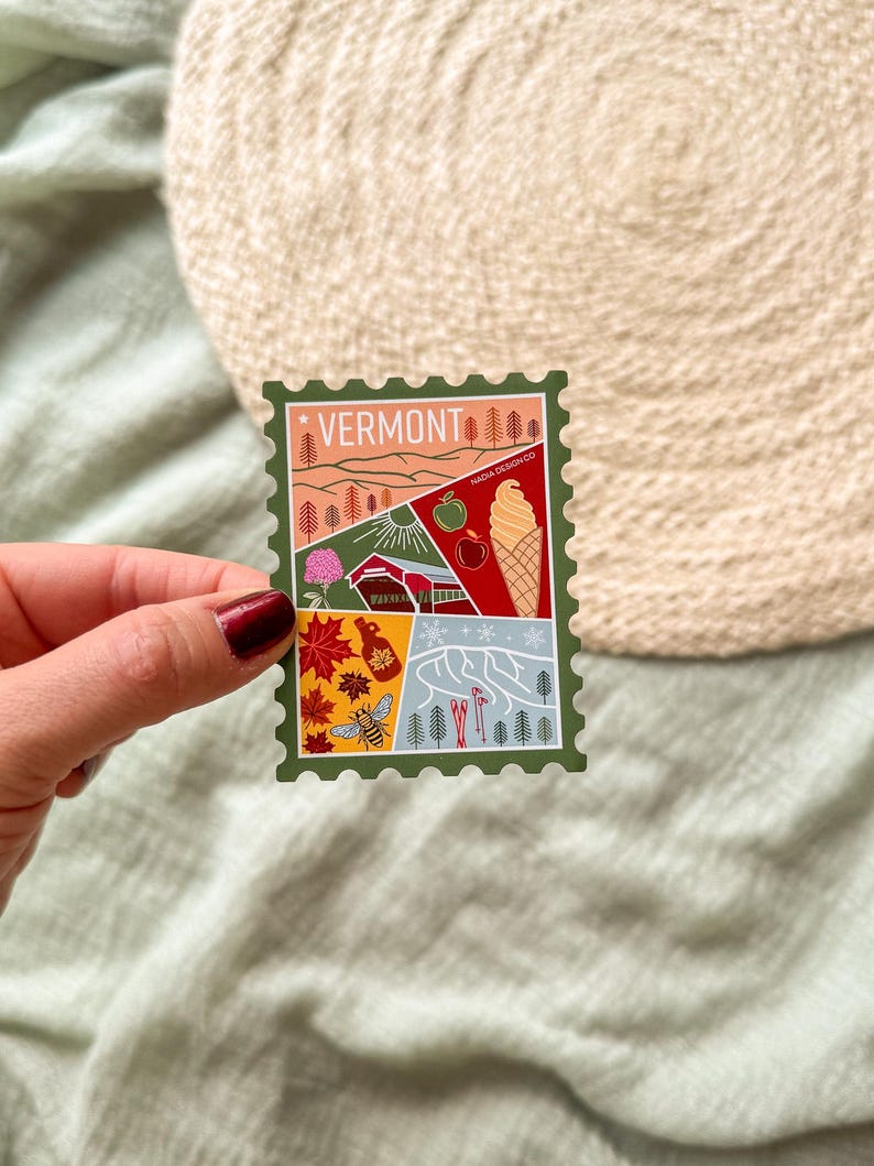 May include: A colorful sticker with a Vermont theme. The sticker features illustrations of a mountain landscape, an apple, an ice cream cone, and other Vermont icons. The word "VERMONT" is printed at the top.