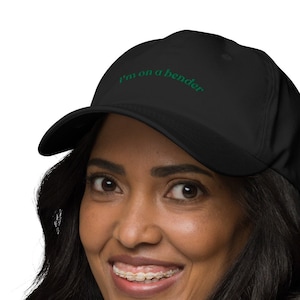 May include: A black baseball cap with the text "I'm on a bender" embroidered in green on the front.