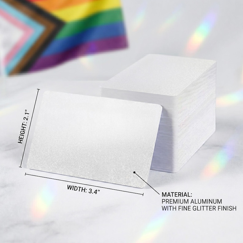 May include: A stack of white rectangular cards with rounded corners. The cards are made of premium aluminum with a fine glitter finish. The height is 2.1 inches, and the width is 3.4 inches. A Pride flag is visible in the background.