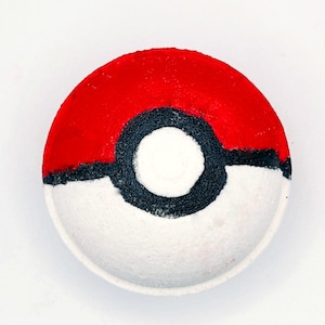 Könnte beinhalten: Eine weiße Badebombe mit einem roten und schwarzen Pokeball-Design.