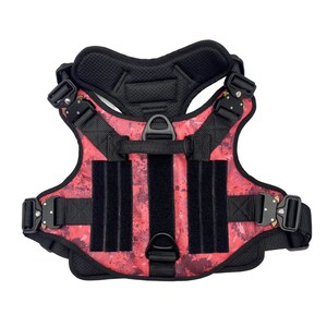 May include: A red and black dog harness with adjustable straps and a padded chest piece. The harness has a camouflage pattern and multiple D-rings for leash attachment.