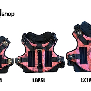May include: Three pink and black dog harnesses with adjustable straps and buckles. The harnesses are labeled "Medium", "Large", and "Extra Large".